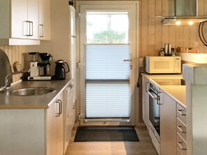 A compact kitchen with a built-in oven, a microwave, and a coffee maker.