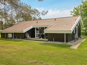 A two-story building with a sloped roof, a covered porch, and a satellite dish. - 5 Star Holiday Home in Jerup (Jerup)