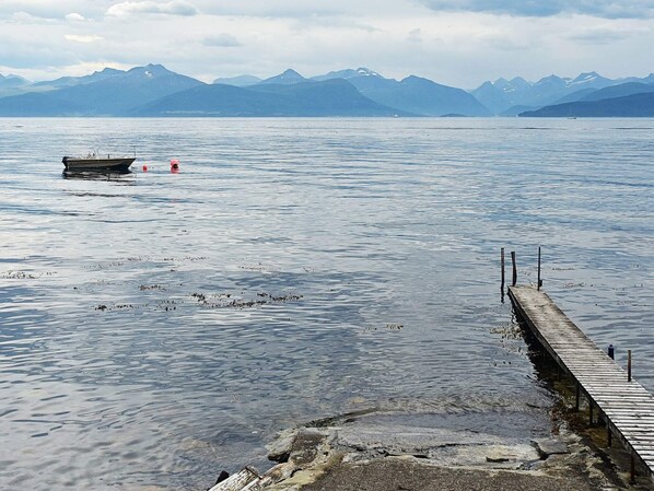 A calm lake with a wooden dock extending into the water, surrounded by mountains. - 5 Person Holiday Home in Molde (Molde)