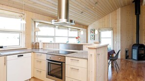 Una cocina moderna con armarios de madera, una campana extractora de acero inoxidable y un horno empotrado.