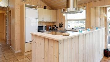 A modern kitchen with wooden cabinetry, a stainless steel range hood, and a central island.