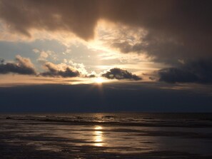 A beach with the sun reflecting on the wet sand. - 5 Star Holiday Home in Hirtshals (Hirtshals)