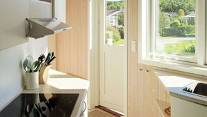 A kitchen with a stove, sink, and window. - 5 Star Holiday Home in Rude (Bisserup)
