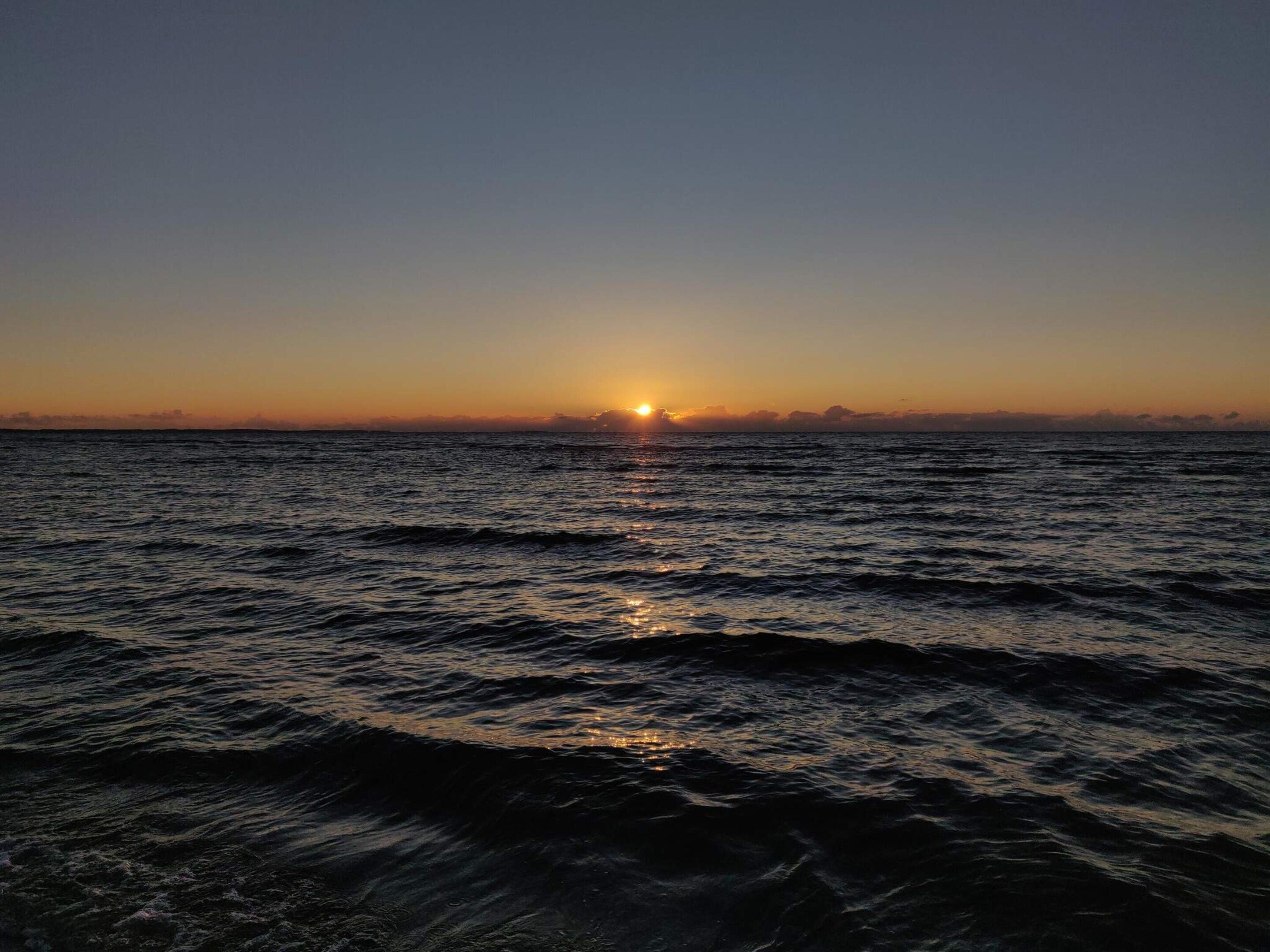A sunset over a body of water with waves.