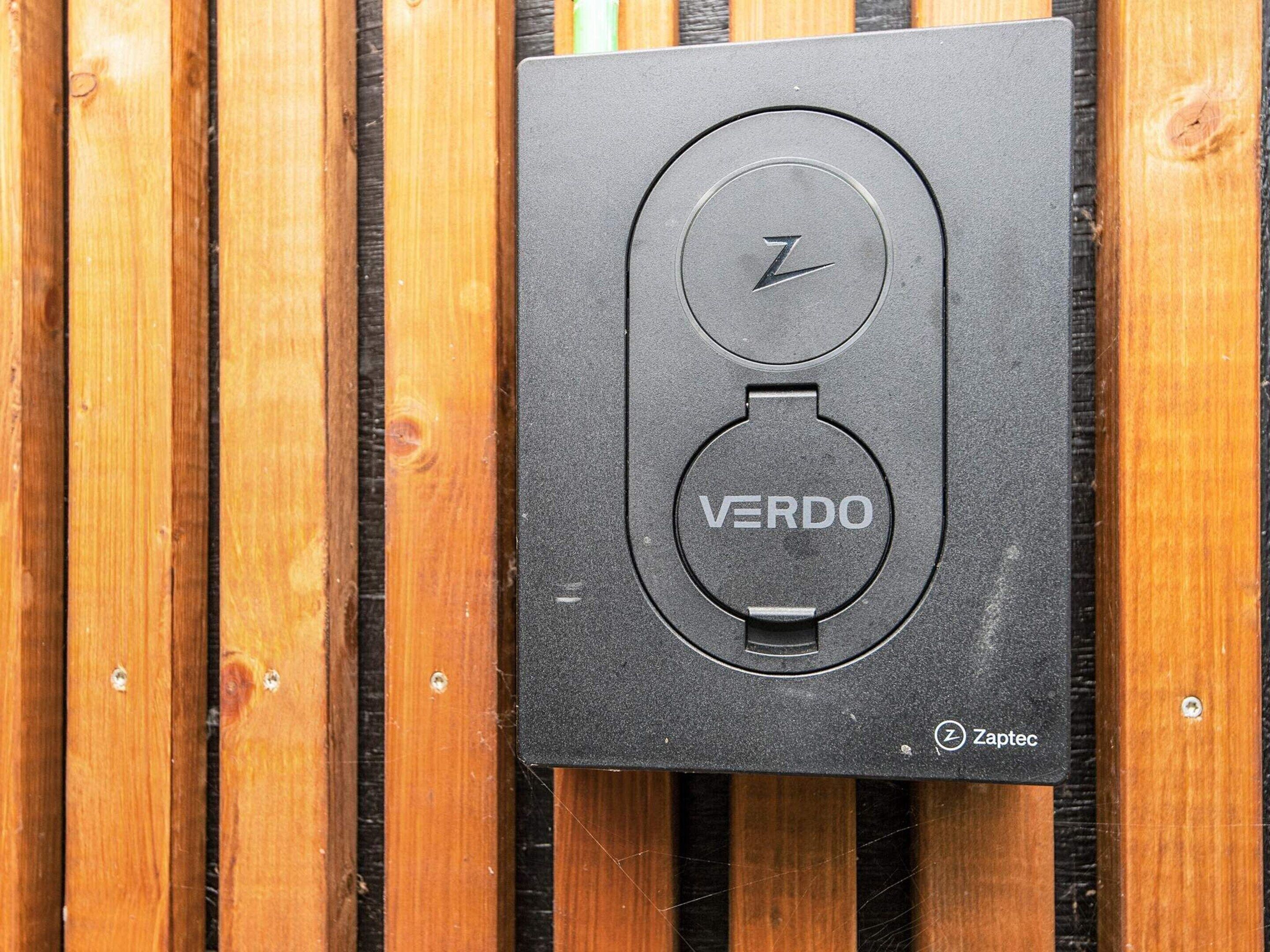 A black box with the brand name "VERDO" and a logo with a lightning bolt, mounted on a wooden surface.