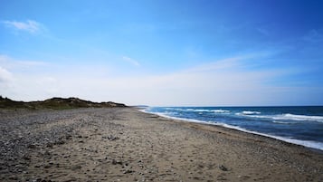 Una playa con orilla pedregosa y olas.