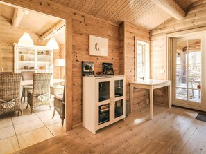 A wooden interior with a dining area, a cabinet with glass doors, and a window. - 4 Star Holiday Home in Frederiksvaerk (Frederiksvaerk)