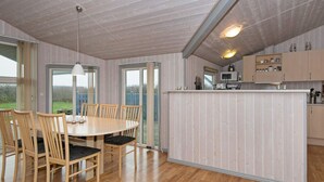 A modern kitchen with wooden cabinets, a microwave, and a small island. - Tranquil Retreat With Spa - By Traum Ferienwohnungen (Hemmet)