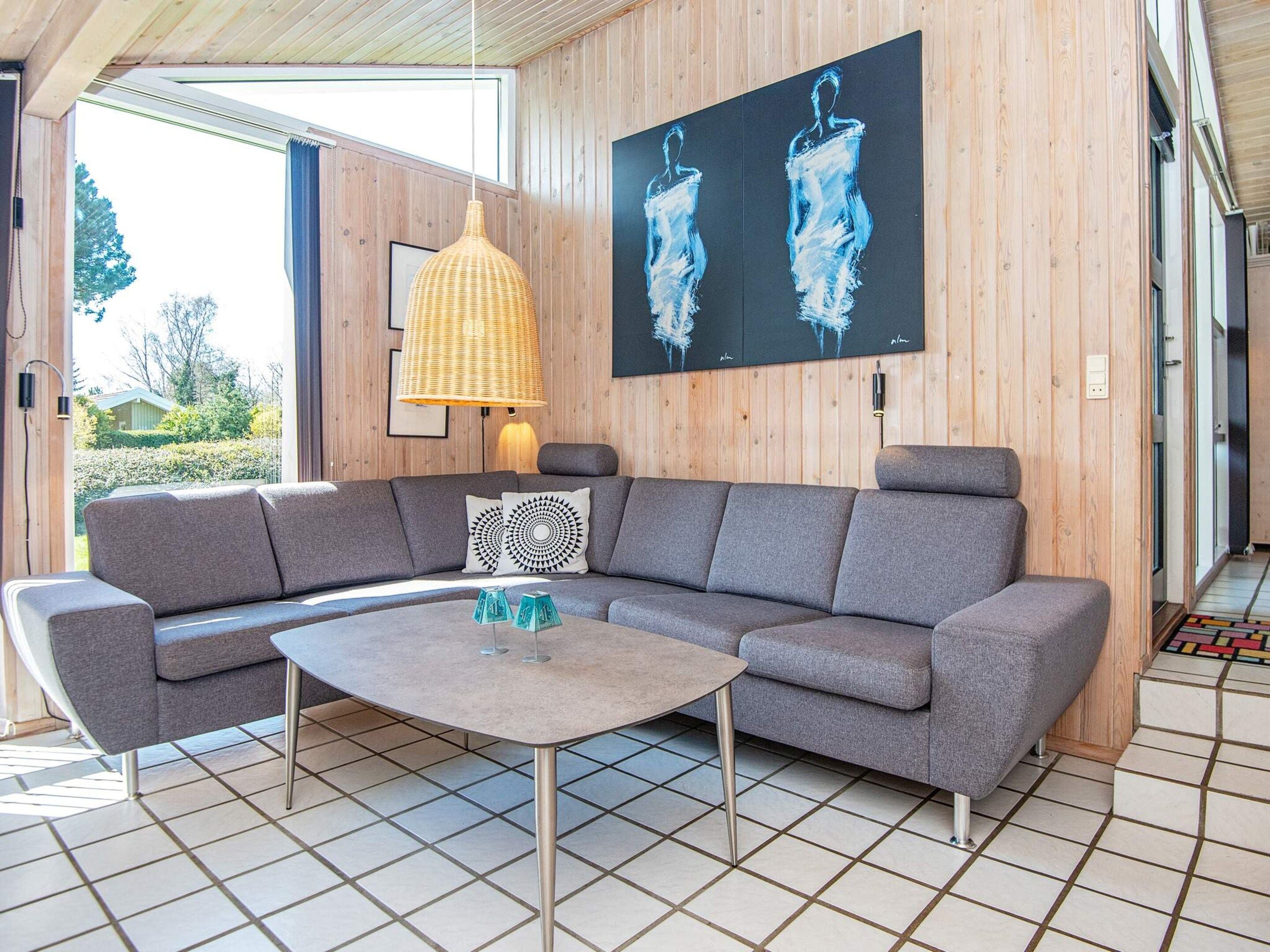 Ein modernes Wohnzimmer mit einer Eckcouch, einem runden Couchtisch und einem großen Gemälde an der Wand.