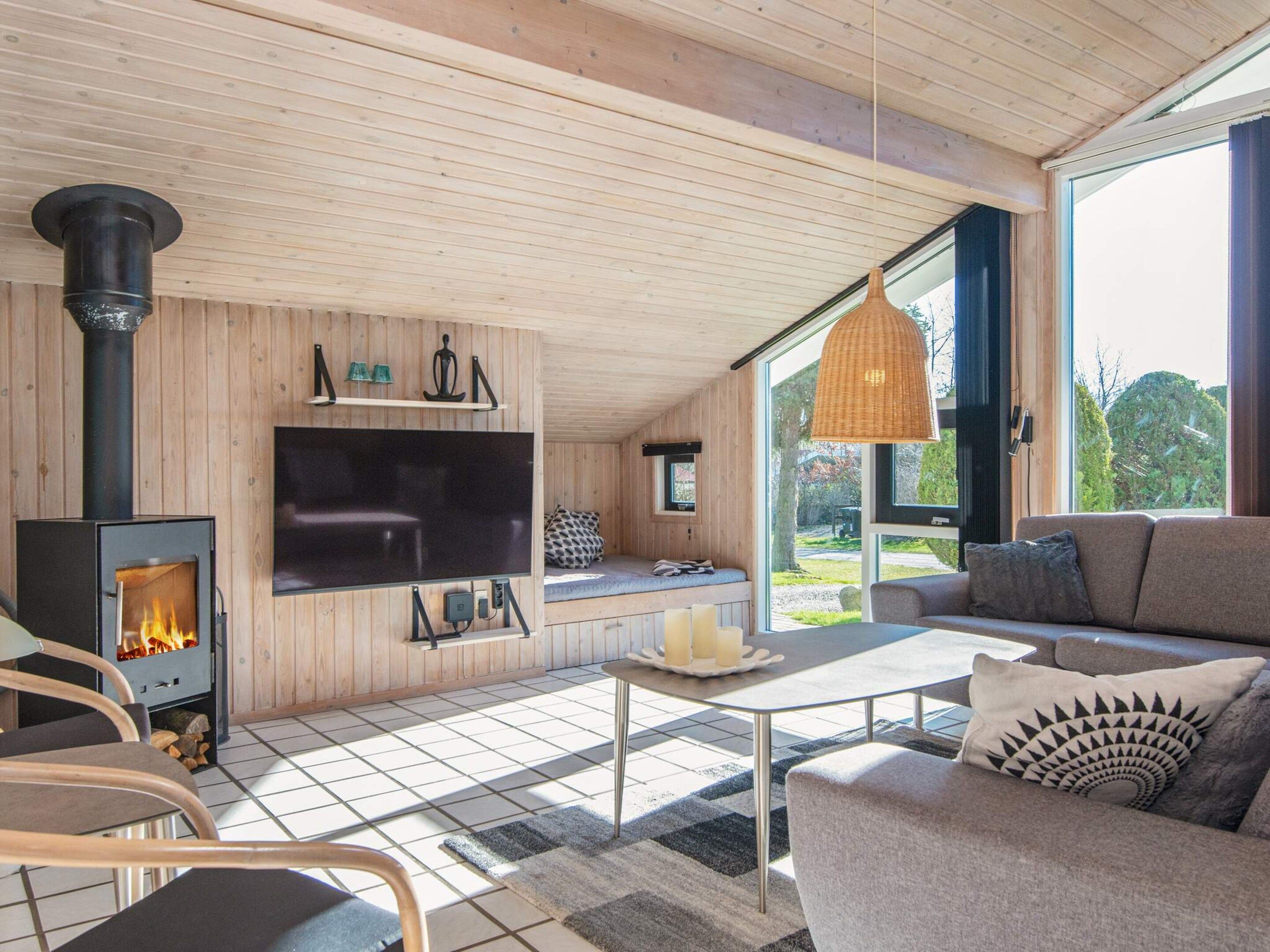 A modern interior with a fireplace, sofa, and large windows.