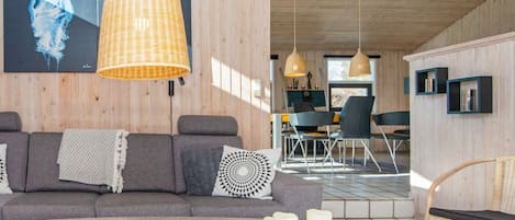 Una sala de estar moderna con un sofá, una mesa de centro y un comedor con sillas y una mesa.