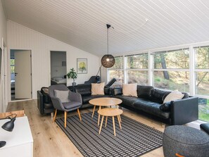 A modern living room with a sectional sofa, a round coffee table, and a patterned rug. - 5 Star Holiday Home in Jerup (Jerup)