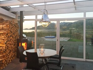 A patio area with a stone wall, a glass table, and chairs.