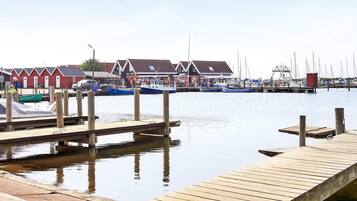 En lysthavn med træbrygger, både og en række bygninger i traditionel arkitektur.