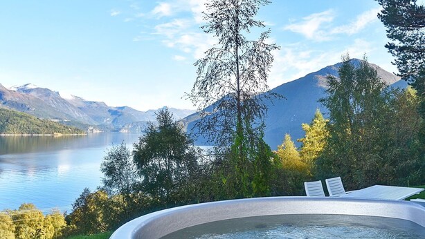 Un jacuzzi con vistas a un lago y montañas.