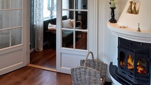 Una habitación con chimenea, una cesta de mimbre y una cama con ventana.