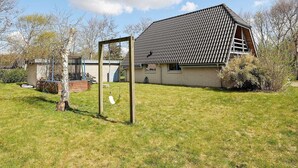 A house with a sloped roof and a wooden swing set in the yard. - 6 Person Holiday Home in Hurup Thy-by Traum (Hurup Thy)