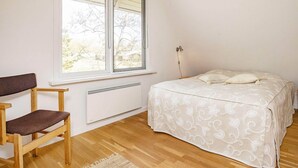 A bedroom with a bed, a chair, a radiator, and a window with blinds. - 6 Person Holiday Home in Hurup Thy-by Traum (Hurup Thy)