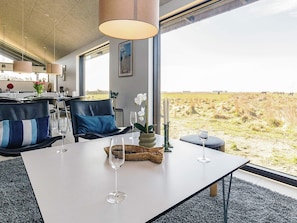 A dining area with a table, chairs, and a view of a field.