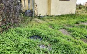 A grassy area with a small building, possibly a shed or a small structure, with a door and windows. - 5 Star Holiday Home in Lokken (Lokken)