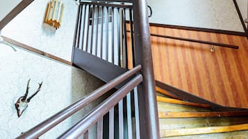 A wooden staircase with metal railings and a patterned wall.
