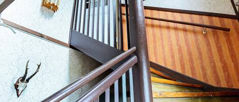 A wooden staircase with metal railings and a patterned wall.