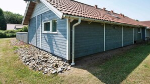 Ein eingeschossiges Gebäude mit rotem Ziegeldach, einer Satellitenschüssel und einem kleinen Fenster.