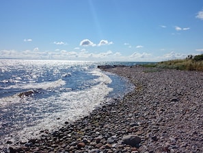 A rocky beach with waves, clear sky, and distant land. - 4 Star Holiday Home in Sydals (Sydals)