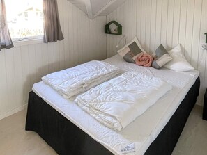 A neatly made bed with white bedding and a black skirted bed base. - 4 Star Holiday Home in Sydals (Sydals)