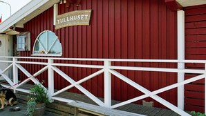 Ein rotes Gebäude mit weißer Brüstung und einem Schild, auf dem 'TULLHUSET' steht.