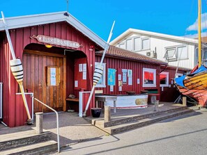 Un bâtiment rouge avec une porte en bois et une enseigne sur laquelle on peut lire « MUSÉE DES POISSONS ».