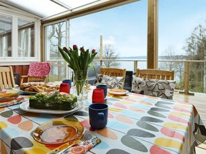 Une table à manger dressée avec des assiettes, des couverts et un vase de fleurs, offrant une vue panoramique.