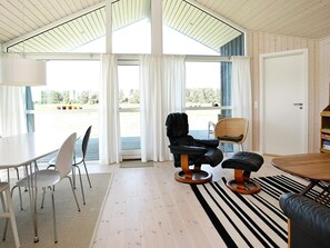 A modern interior with a dining area, a lounge chair, and a sofa. - 5 Star Holiday Home in Lokken (Lokken)