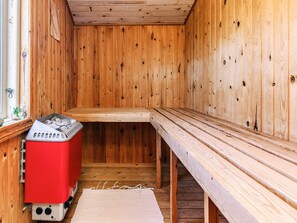 A sauna room with wooden walls and benches.