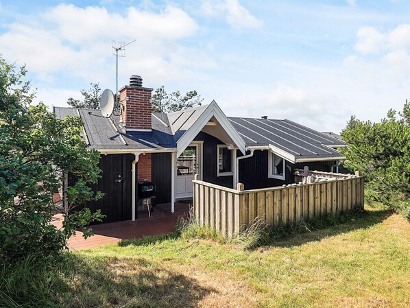 A house with a chimney, satellite dish, and a fenced backyard.
