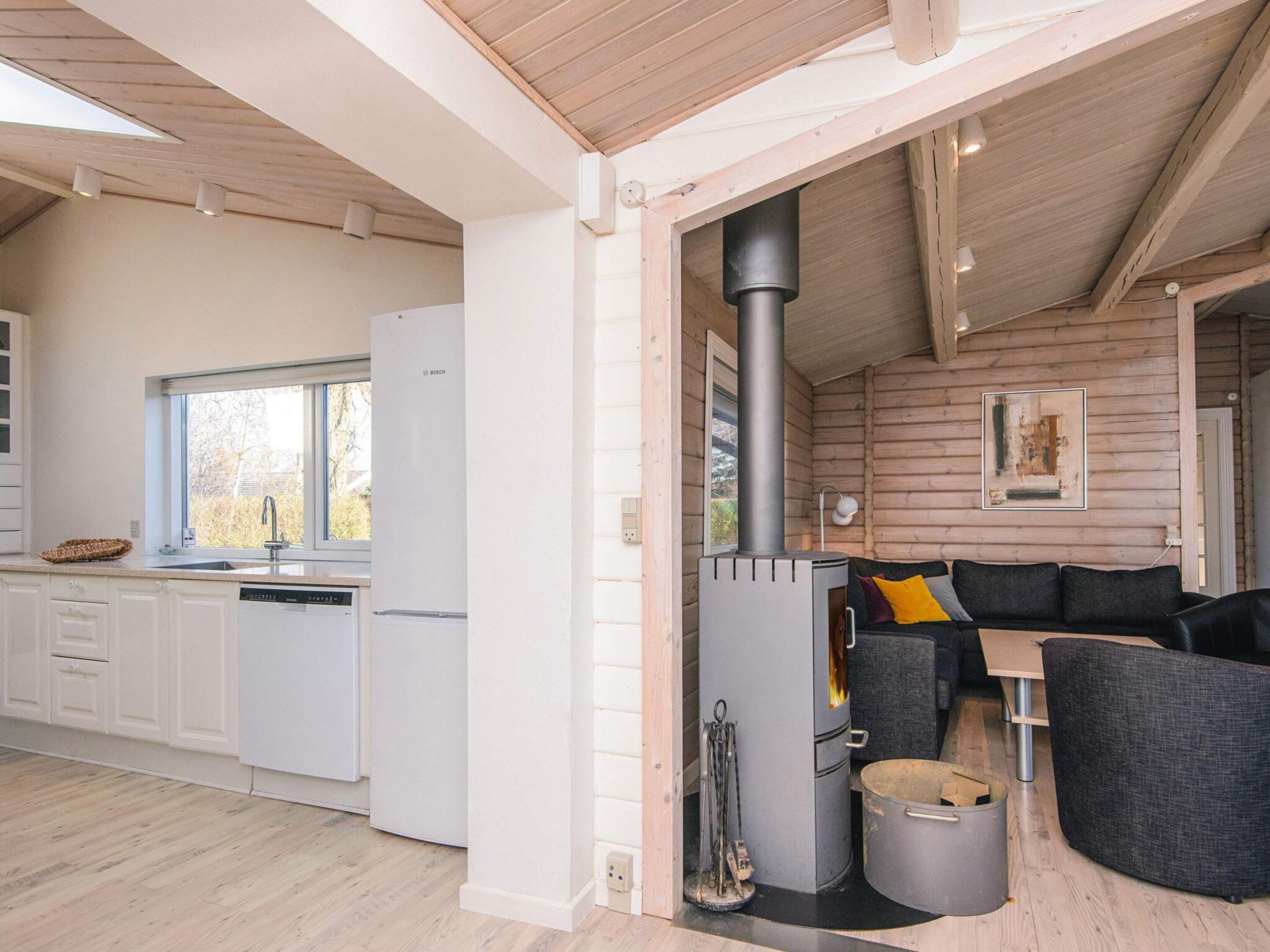 A modern kitchen with white cabinets, a Bosch dishwasher, and a window.