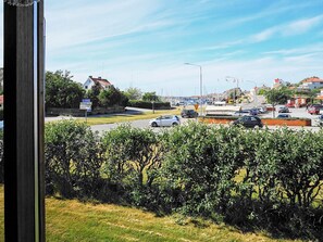A view of a road with cars, a pedestrian crossing, and buildings in the background. - Holiday Home in Skärhamn (Skaerhamn)