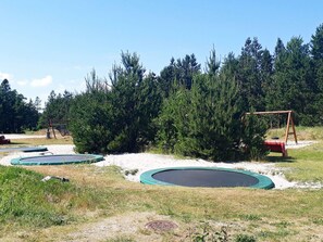 A playground with multiple trampolines and a swing set. - 9 Person Holiday Home in Jerup (Jerup)