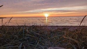 A beach with grass in the foreground and a sunset over the water. - 2 Person Holiday Home in Tarm (Tarm)