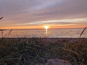 A beach scene with grass in the foreground and a sunset over the water. - 2 Person Holiday Home in Tarm (Tarm)