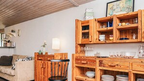A cozy living room with a wooden dining area, a sofa, and a chair. - 2 Person Holiday Home in Tarm (Tarm)