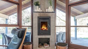 A modern interior with a fireplace, seating area, and large windows. - 4 Star Holiday Home in Skals (Skals)
