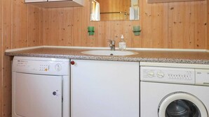 A compact kitchen with a washing machine, a dishwasher, and a sink. - 6 Person Holiday Home in Hadsund-by Traum (Hadsund)