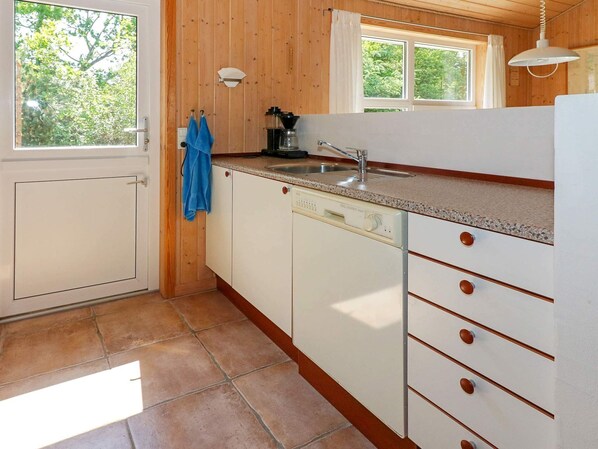 Una cocina con lavavajillas, un lavabo y una ventana.
