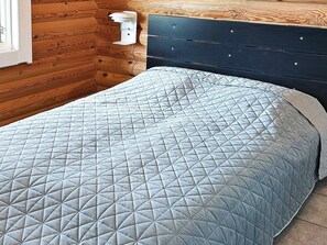 A bed with a quilted headboard and a bedside table with a lamp. - 4 Star Holiday Home in Sydals (Sydals)