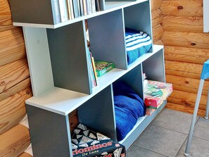 A bookshelf with various books and board games.