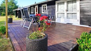 A wooden deck with outdoor seating and a potted plant. - 4 Person Holiday Home in Jerup (Jerup)