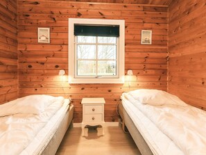 Une chambre de cabine avec deux lits, une fenêtre et une petite table de chevet.