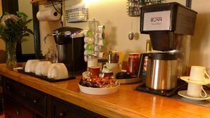A coffee station with a Bunn coffee machine, tea kettle, and various coffee and tea containers. - Deer Run Lodging House (Skaneateles)