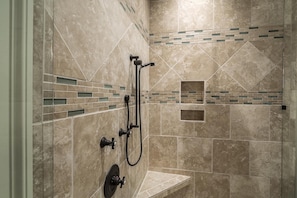 A shower area with a handheld showerhead and a wall-mounted faucet. - Deer Run Lodging House (Skaneateles)
